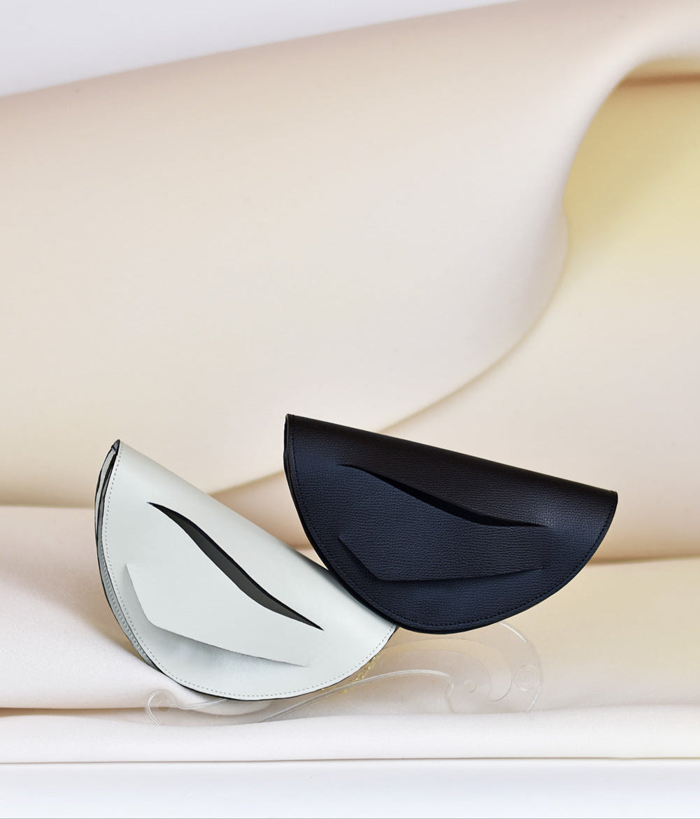 Handmade clutch bag, genuine Italian leather, off white, black handbag, crossbody purse with unique wrist strap by Hungarian, Budapest based designer. Fekete, fehér bőr designer borítéktáska, táska, válltáska magyar táskatervező márka.