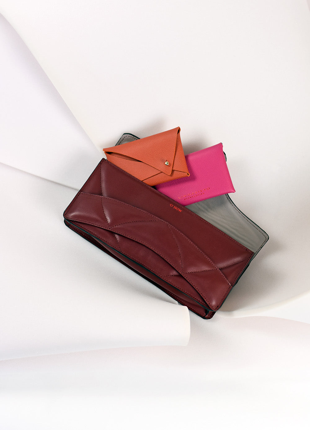 Handmade clutch bag handcrafted from genuine Italian leather, custom colors, black red burgundy garnet wine handbag, crossbody purse with unique wrist strap by Hungarian, Budapest based designer. Fekete, bordó választható színű bőr designer borítéktáska, táska, válltáska magyar táskatervező márka.