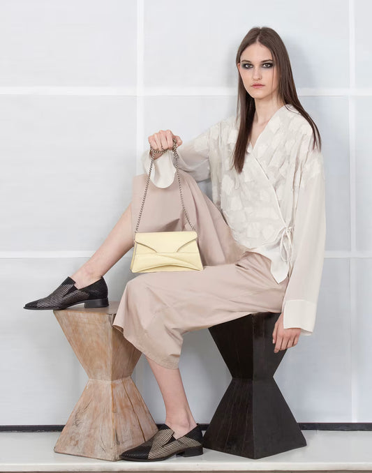 Butter pastel yellow textured, genuine leather designer clutch to crossbody bag, purse with unique wrist strap, silver chain strap by Budapest based fashion brand. Egyedi, magyar valódi bőr táska, pasztell, vaj sárga női táska, ezüst lánc vállpánttal.