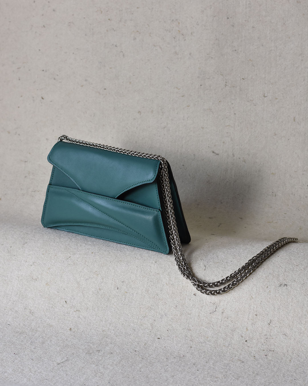 Jade green leather designer clutch to crossbody bag, purse with unique wrist strap, silver chain strap by Budapest based fashion brand. Egyedi magyar bőr borítéktáska, zöld női táska, ezüst lánc vállpánttal.