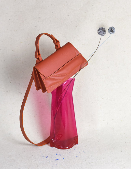 Magyar designer bőr crossbody táska, egyedi válltáska, különleges csuklópánt design. Handmade orange genuine leather crossbody bag by Budapest based fashion designer, unique wrist strap.