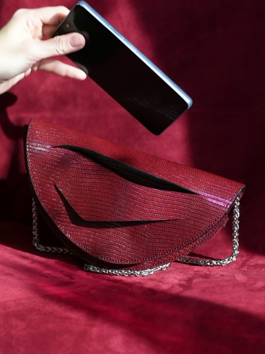 Video showing what fits inside a Lindasieto sculptural Mini Dune Bag, convertible clutch on chain with wrist strap in dark red, burgundy Italian leather. Limited numbers, custom colors, personalization, Budapest based designer. Lindasieto Mini Dune egyedi bordó bőr designer táska, magyar iparművész táska tervező, prémium olasz bőrök, személyre szabott ajándék, monogram, magyar márka.