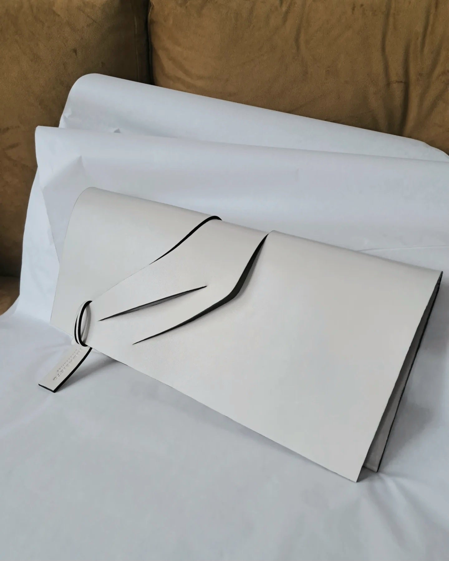 Handmade clutch bag handcrafted from genuine Italian leather, custom colors, off white handbag, purse with unique wrist strap by Hungarian, Budapest based designer. Fehér, törtfehér választható színű bőr designer borítéktáska, táska, magyar táskatervező márka.