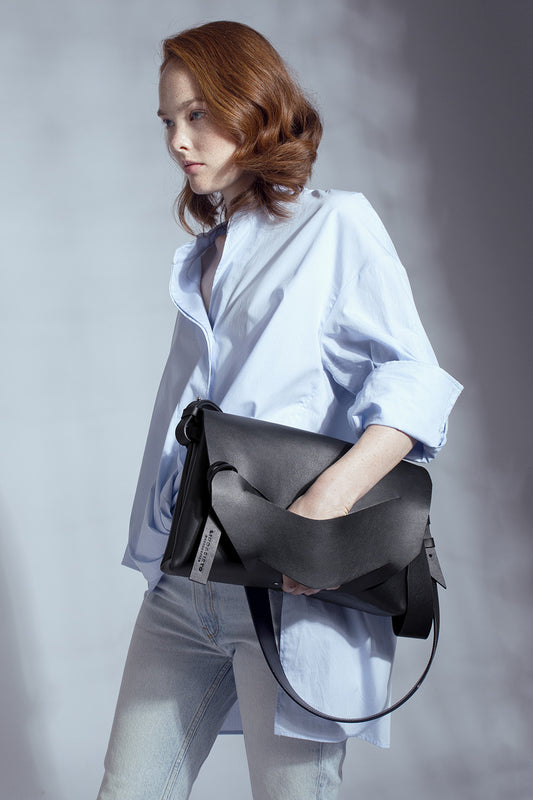 Handmade black Italian genuine leather sculptural handbag, crossbody, oversize, soft clutch bag with unique wrist strap by Hungarian, Budapest based designer. Bőr designer válltáska, táska, magyar táskatervező márka.