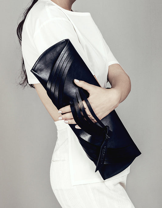 Handmade sculptural clutch bag handcrafted from genuine Italian leather, custom colors, black handbag, purse with unique signature wrist strap by Hungarian, Budapest based designer. Fekete, választható színű bőr designer borítéktáska, táska, magyar táskatervező márka.