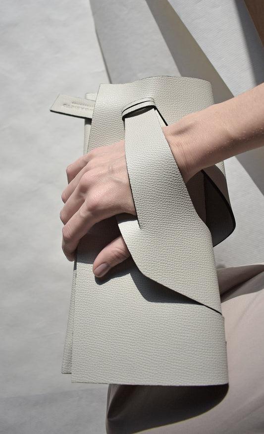 Personalized clutch bag handcrafted from genuine Italian leather, custom colors, off white handbag, purse with unique wrist strap by Hungarian, Budapest based designer. Fehér, választható színű bőr designer borítéktáska, táska, magyar táskatervező márka.