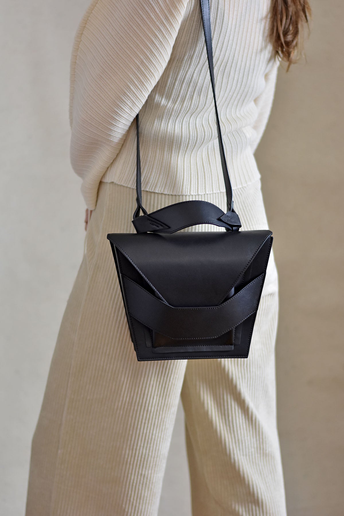 Handmade clutch bag handcrafted from genuine Italian leather, custom colors, black handbag, crossbody purse with unique wrist strap by Hungarian, Budapest based designer. Fekete, választható színű bőr designer borítéktáska, táska, válltáska magyar táskatervező márka.