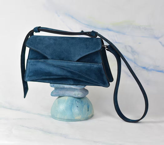 lindasieto_sculptural_link_bag_azure_blue_suede_leather_designer_clutch_shoulder_bag_hybrid_on_painted_ornament_pastel_background_magyar_velur_bor_taska_makers_market