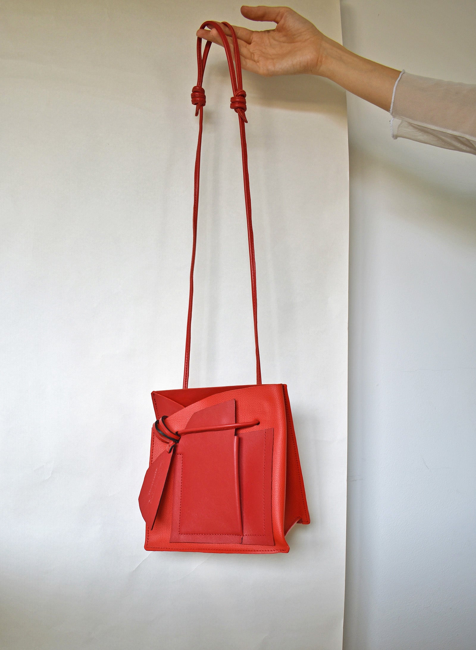 Piros magyar designer táska márka, táskatervező, egyedi design. Red leather bucket bag, unique crossbody style.