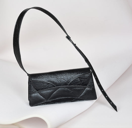 Avantgarde black Italian genuine leather, or vegan handbag, crossbody, oversize, soft clutch bag with unique wrist strap by Hungarian, Budapest based designer. Bőr designer válltáska, táska, magyar táskatervező márka.