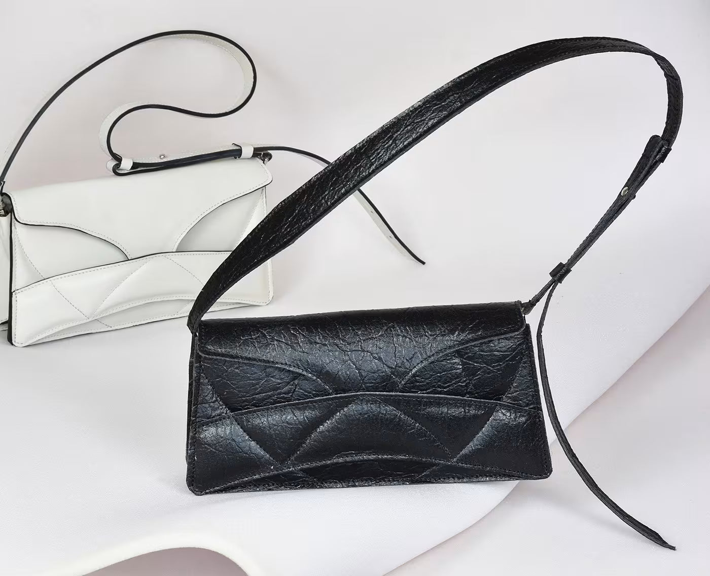 Avantgarde black Italian genuine leather, or vegan handbag, crossbody, oversize, soft clutch bag with unique wrist strap by Hungarian, Budapest based designer. Bőr designer válltáska, táska, magyar tervezői táskamárka.
