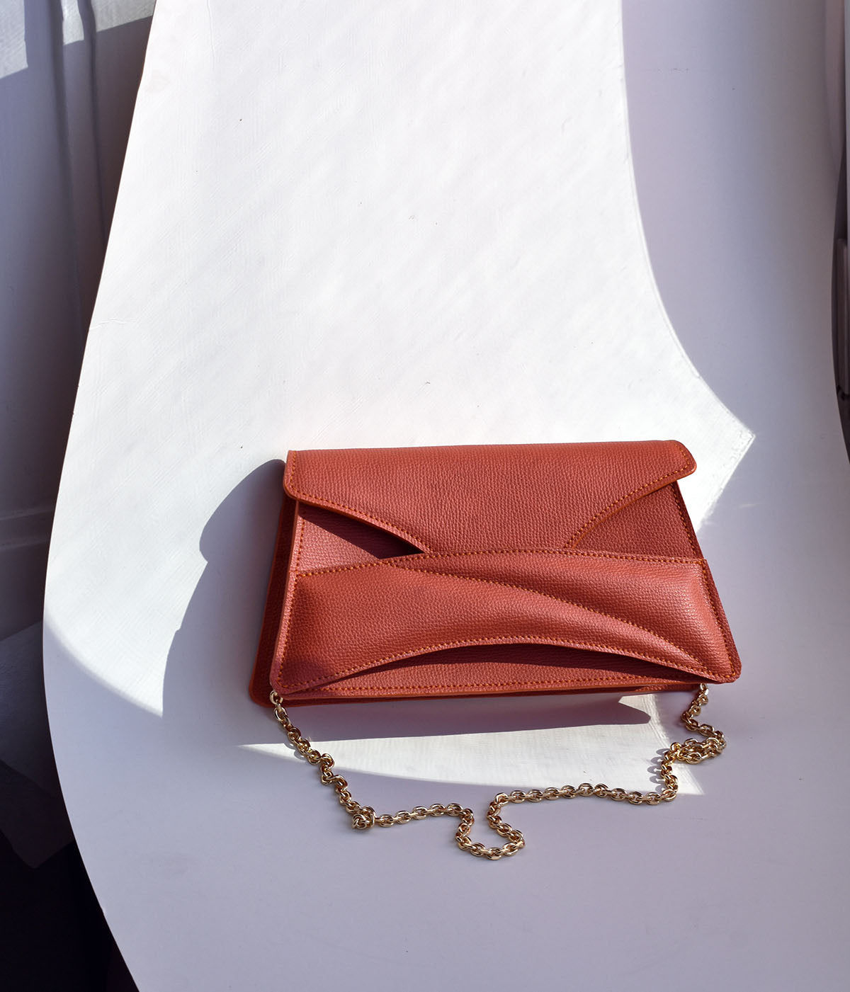 Handmade clutch bag handcrafted from genuine Italian leather, custom colors, orange red handbag, crossbody purse with unique wrist strap by Hungarian, Budapest based designer. Narancs, választható színű bőr designer borítéktáska, táska, válltáska magyar táskatervező márka.