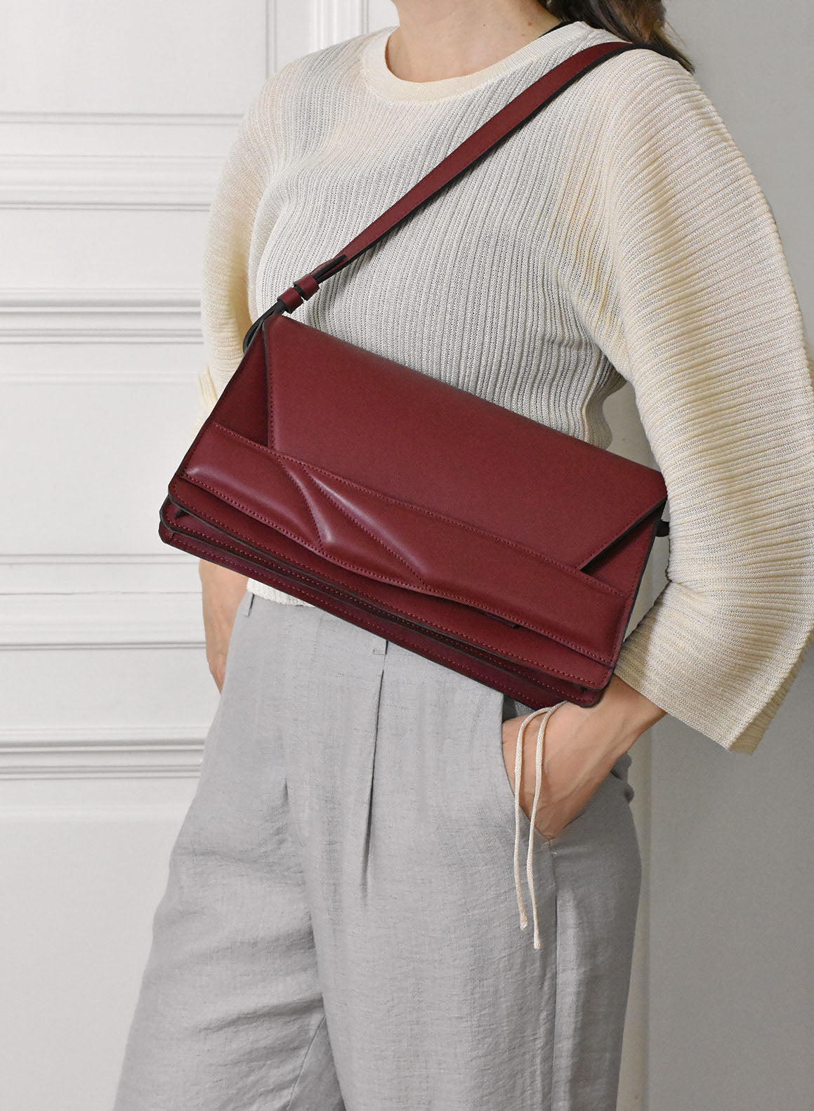Handmade clutch bag handcrafted from genuine Italian leather, custom colors, black red burgundy garnet wine handbag, crossbody purse with unique wrist strap by Hungarian, Budapest based designer. Fekete, bordó választható színű bőr designer borítéktáska, táska, válltáska magyar táskatervező márka.