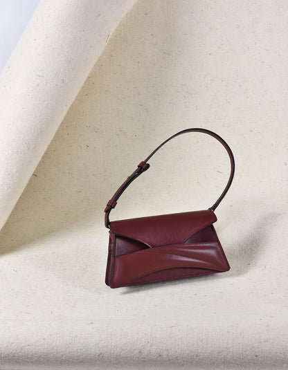 Handmade clutch bag handcrafted from genuine Italian leather, custom colors, dark red, burgundy, garnet, wine red handbag, crossbody purse with unique wrist strap by Hungarian, Budapest based designer. Bordó, piros választható színű bőr designer borítéktáska, táska, válltáska magyar táskatervező márka.