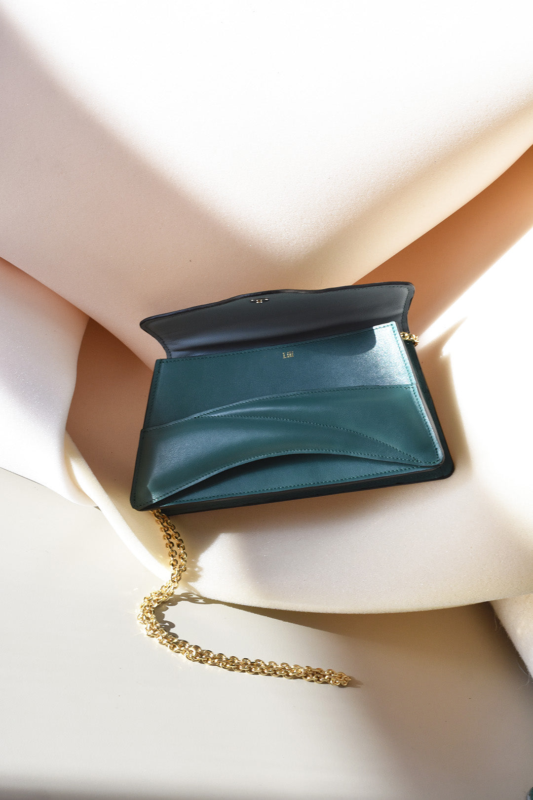 Handmade clutch bag handcrafted from genuine Italian leather, custom colors, black green lilac purple handbag, crossbody purse with unique wrist strap by Hungarian, Budapest based designer. Fekete, lila zöld választható színű bőr designer borítéktáska, táska, válltáska magyar táskatervező márka.