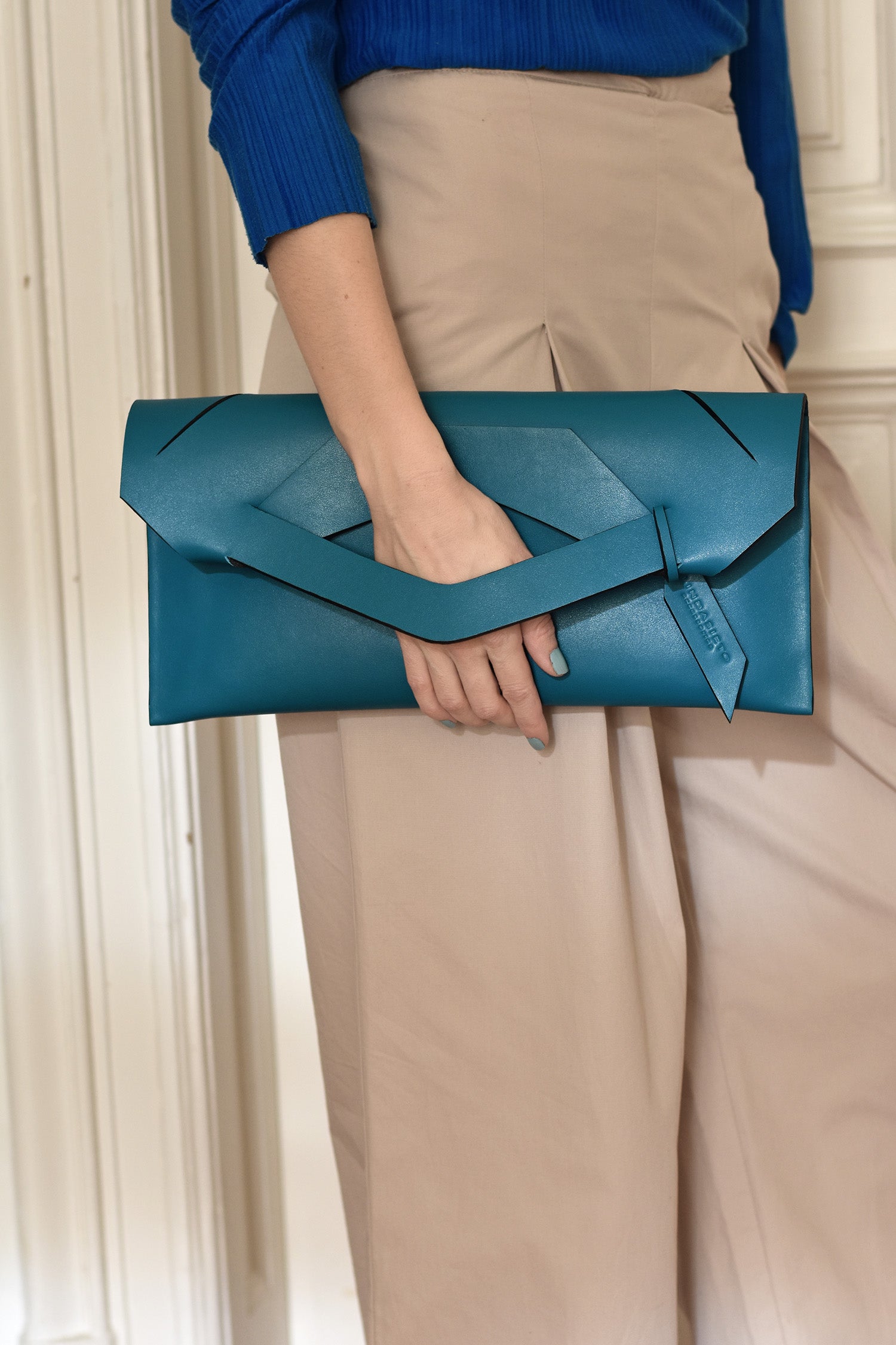 Lindasieto prémium, türkiz kék, alkalmi, valódi bőr Triangular Slashed designer clutch táska, magyar tervezői táska márka, monogrammal. Personalised, sculptural, teal blue Italian nappa leather, handmade elegant occasion clutch bag, unique wrist strap, wedding clutch gift, Budapest fashion brand.