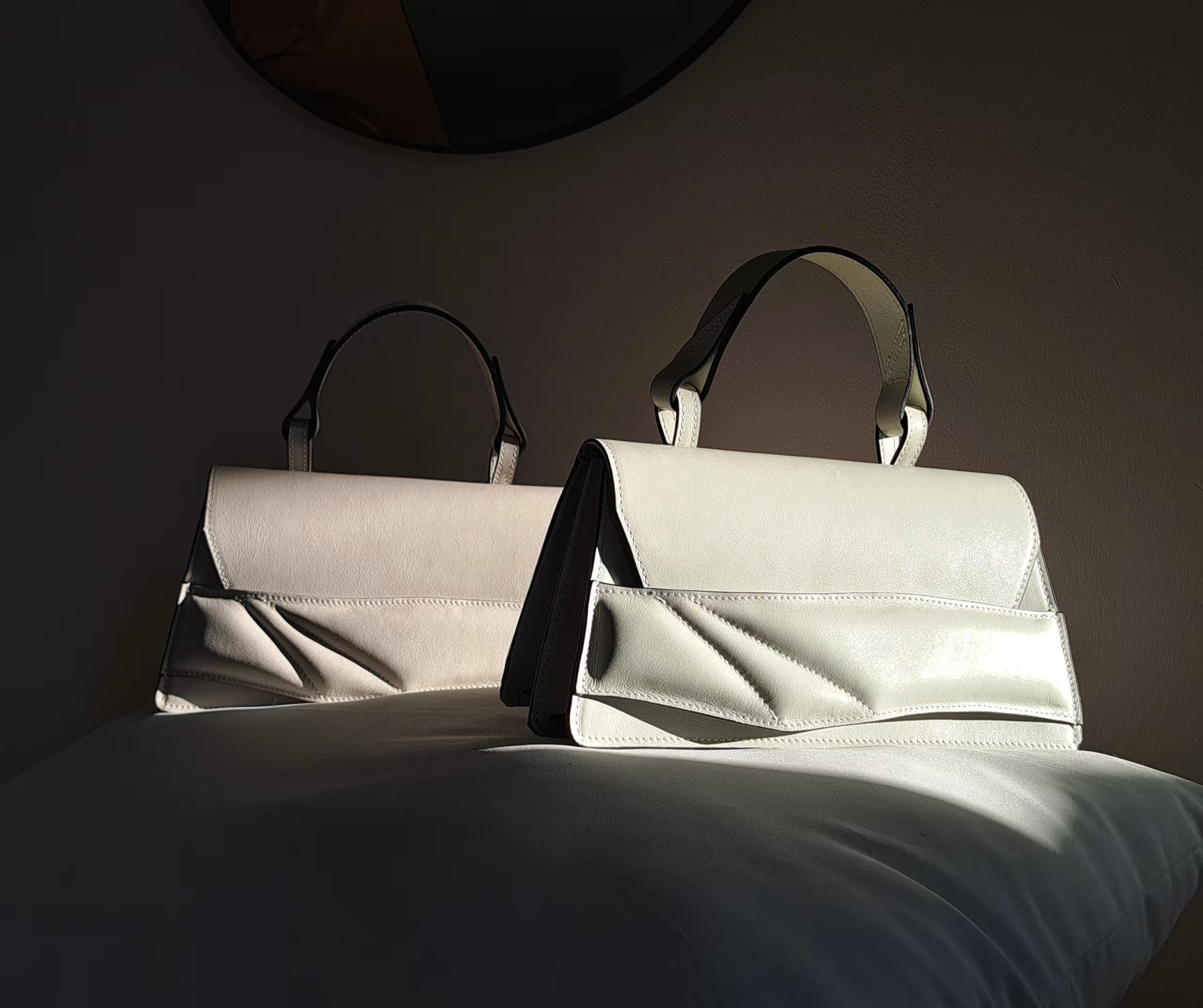 Lindasieto sculptural minimalist Mini Balance milky pistachio light green, off white neutral nappa leather crossbody bags by Budapest based fashion designer, unique wrist strap handle. Magyar kortárs designer pisztácia zöld, törtfehér bőr Mini Balance crossbody táska, egyedi, női, uniszex, válltáska.