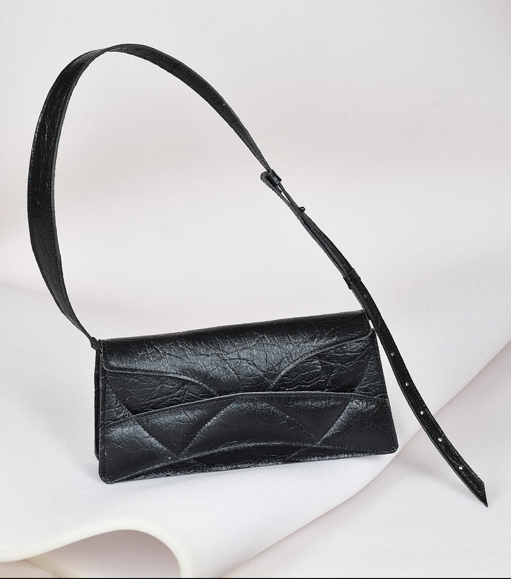 Avantgarde black Italian genuine leather, or vegan handbag, crossbody, oversize, soft clutch bag with unique wrist strap by Hungarian, Budapest based designer. Bőr designer válltáska, táska, magyar táskatervező márka.