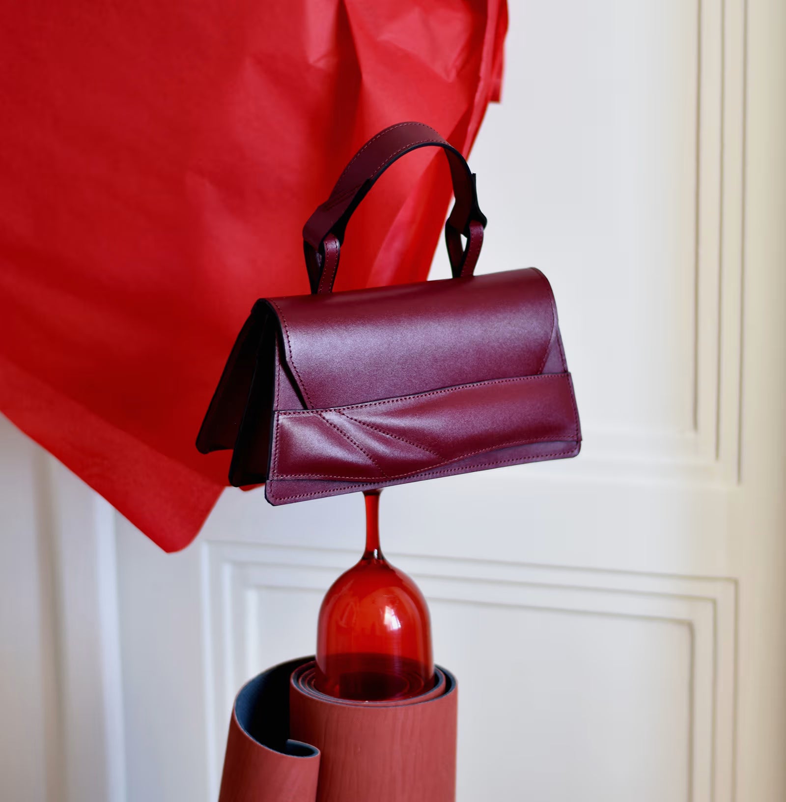 Lindasieto, sculptural, structured Mini Balance Bag crafted from premium Italian nappa leather, black cherry red, oxblood coloured handbag, crossbody purse with unique wrist strap by Budapest based designer Linda Sieto. Egyedi bordó bőr designer táska, kézzel festett élek, magyar tervezői márka.