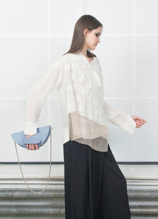 Lindasieto Dune Chain Bag handcrafted from luxurious Italian grained cornflower blue leather, sculptural minimalist handbag, crossbody purse with unique wrist strap by Hungarian, Budapest based designer. Pasztell kék bőr kortárs designer válltáska magyar táska tervező márka.