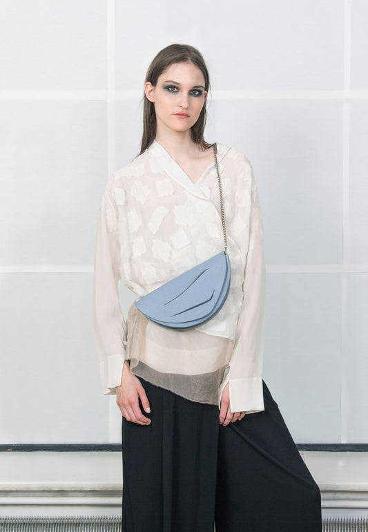 Lindasieto Dune Chain Bag handcrafted from luxurious Italian grained cornflower blue leather, sculptural minimalist handbag, crossbody purse with unique wrist strap by Hungarian, Budapest based designer. Pasztell kék bőr kortárs designer válltáska magyar táska tervező márka.
