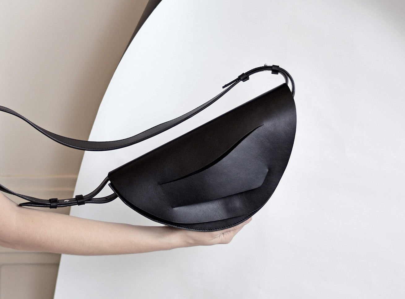 Lindasieto Mini Dune, fekete bőr magyar designer táska, válltáska, tervezői márka. Sculptural, minimalist clutch bag, genuine Italian leather, custom colors, black handbag, luxury crossbody purse with unique wrist strap by Hungarian, Budapest based independent designer. 