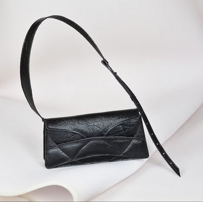 Avantgarde black Italian genuine leather, or vegan handbag, crossbody, oversize, soft clutch bag with unique wrist strap by Hungarian, Budapest based designer. Bőr designer válltáska, táska, magyar tervezői táskamárka.