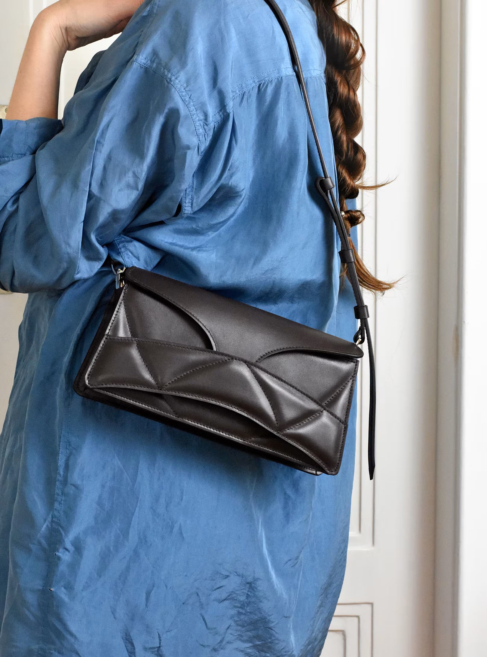 lindasieto magyar designer csokoládé barna nappa  bőr Enigmatic Heart táska, 2026 tavasz színek. Sculptural dark chocolate leather clutch to shoulder bag hybrid with unique wrist strap, abstract heart shaped pattern by Budapest based designer brand.