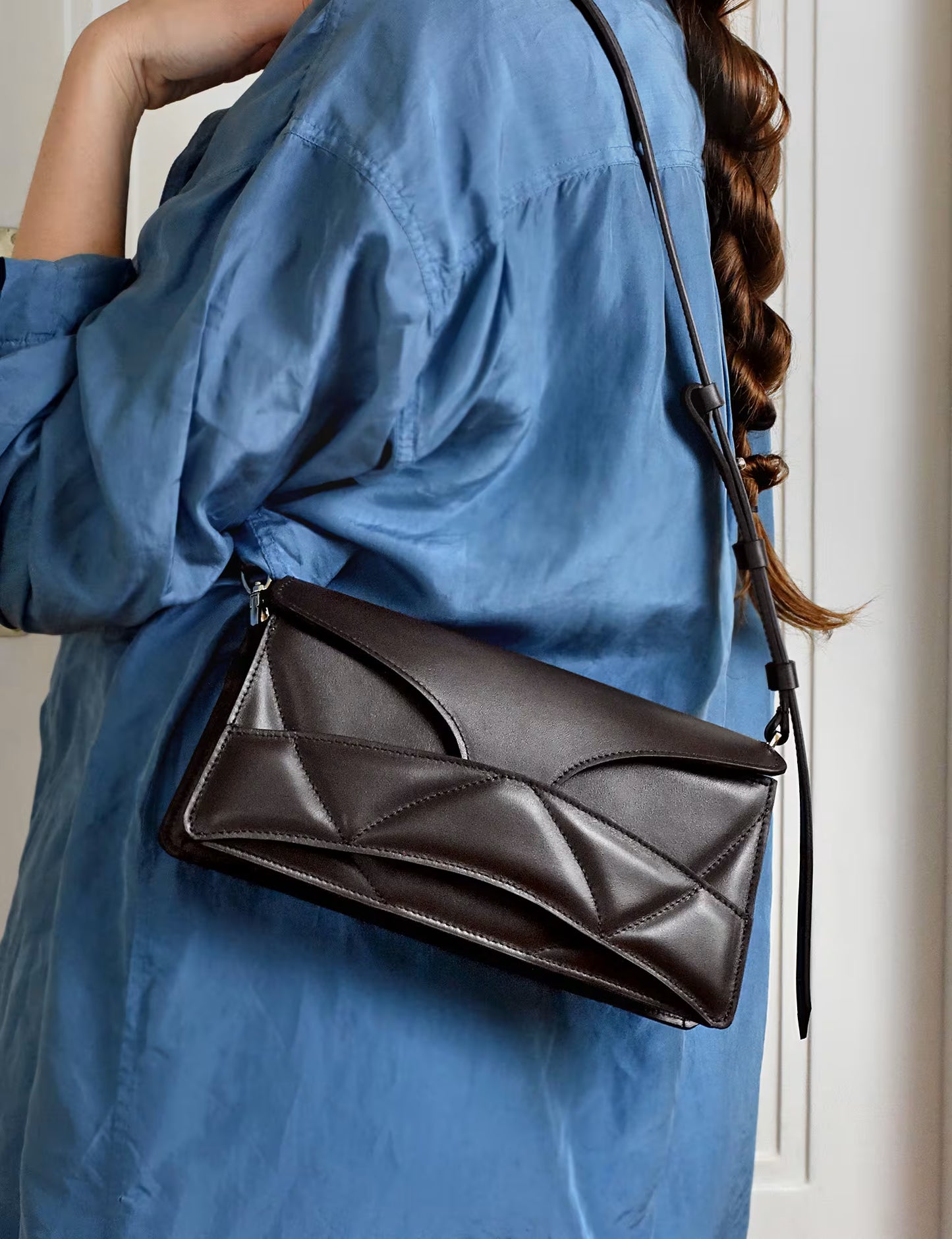 lindasieto magyar designer csokoládé barna nappa  bőr Enigmatic Heart táska, 2026 tavasz színek. Sculptural dark chocolate leather clutch to shoulder bag hybrid with unique wrist strap, abstract heart shaped pattern by Budapest based designer brand, ss26.