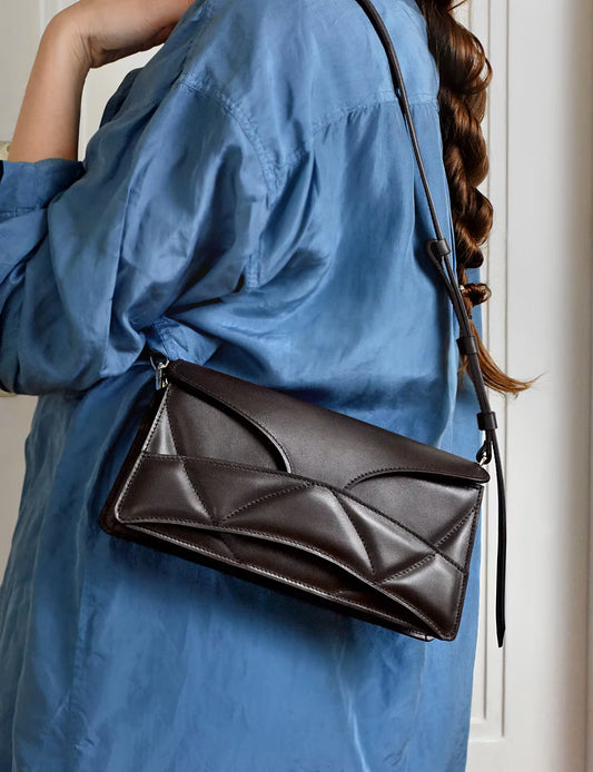 lindasieto magyar designer csokoládé barna nappa  bőr Enigmatic Heart táska, 2026 tavasz színek. Sculptural dark chocolate leather clutch to shoulder bag hybrid with unique wrist strap, abstract heart shaped pattern by Budapest based designer brand, ss26.