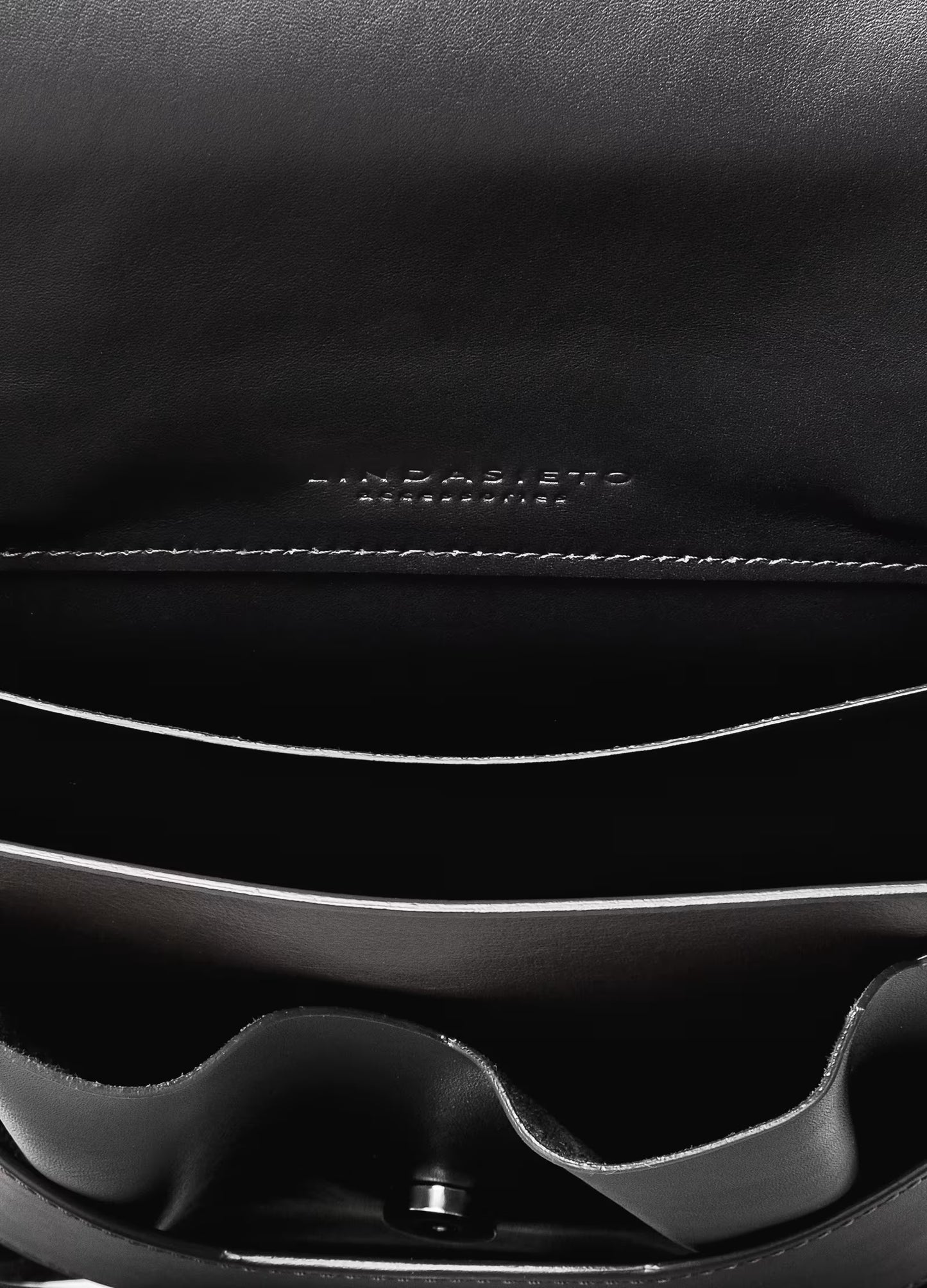 Lindasieto avantgarde edgy Layered Bag handcrafted from luxurious Italian nappa leather, sculptural minimalist black handbag, crossbody purse with unique wrist strap, closeup detail with stitching and inner panels by Hungarian, Budapest based designer. Fekete bőr kortárs designer válltáska magyar táska tervező márka.
