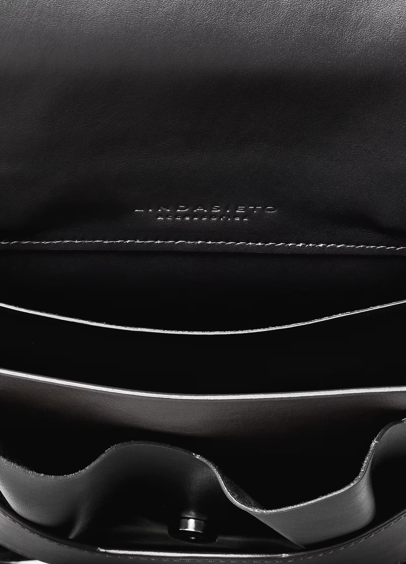 Lindasieto avantgarde edgy Layered Bag handcrafted from luxurious Italian nappa leather, sculptural minimalist black handbag, crossbody purse with unique wrist strap, closeup detail with stitching and inner panels by Hungarian, Budapest based designer. Fekete bőr kortárs designer válltáska magyar táska tervező márka.