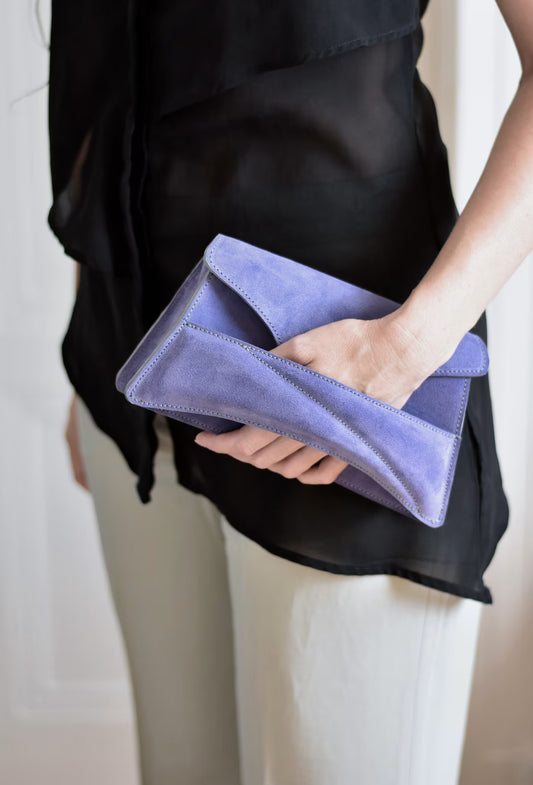 Lindasieto sculptural amethyst lilac suede leather Link Bag, designer handbag in hand with black elegant minimal outfit. Magyar kortárs designer lila velúr bőr alkalmi clutch táska, kézben viselve, elegáns fekete neutrális öltözékkel