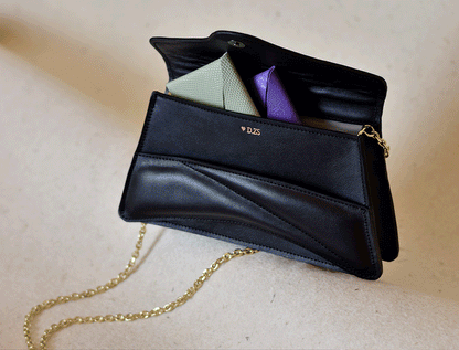 Handmade black Italian genuine leather handbag, crossbody clutch with unique wrist strap by Hungarian, Budapest based designer. Fekete bőr designer válltáska, egyedi táska, magyar táskatervező márka.