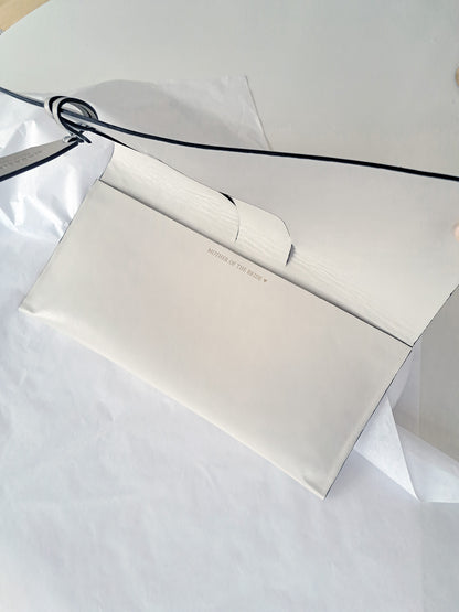 White leather clutch purse with personalised message on a white background