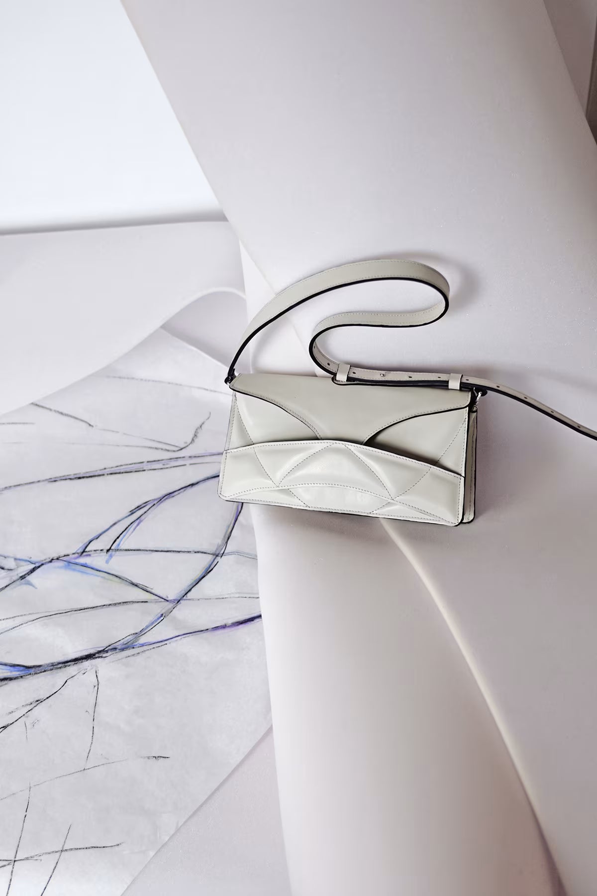 LINDASIETO Pure Heart Bag in off white Italian leather, with unique wrist strap, against original abstract heart shaped design sketch by Budapest based designer. Magyar, designer, fehér bőr válltáska, magyar táskatervező márka.