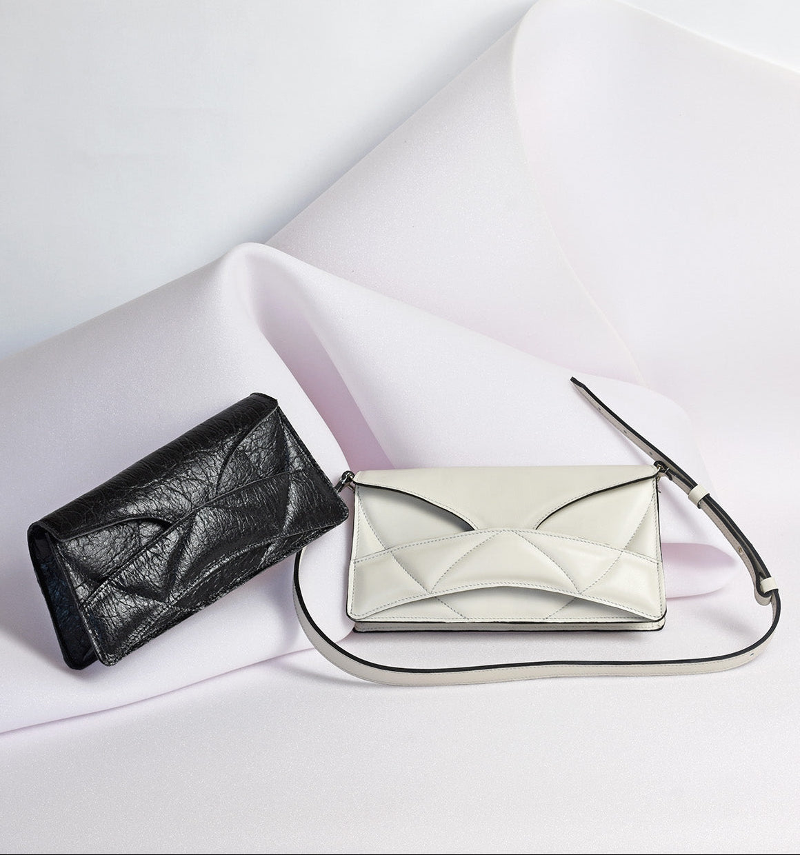 LINDASIETO Pure Heart Bag in off white Italian leather, Enigmatic Heart Bag in vegan, black Pinatex, both with unique wrist strap by Budapest based designer. Magyar, designer, fehér bőr válltáska , fekete vegán táska, magyar táskatervező márka.