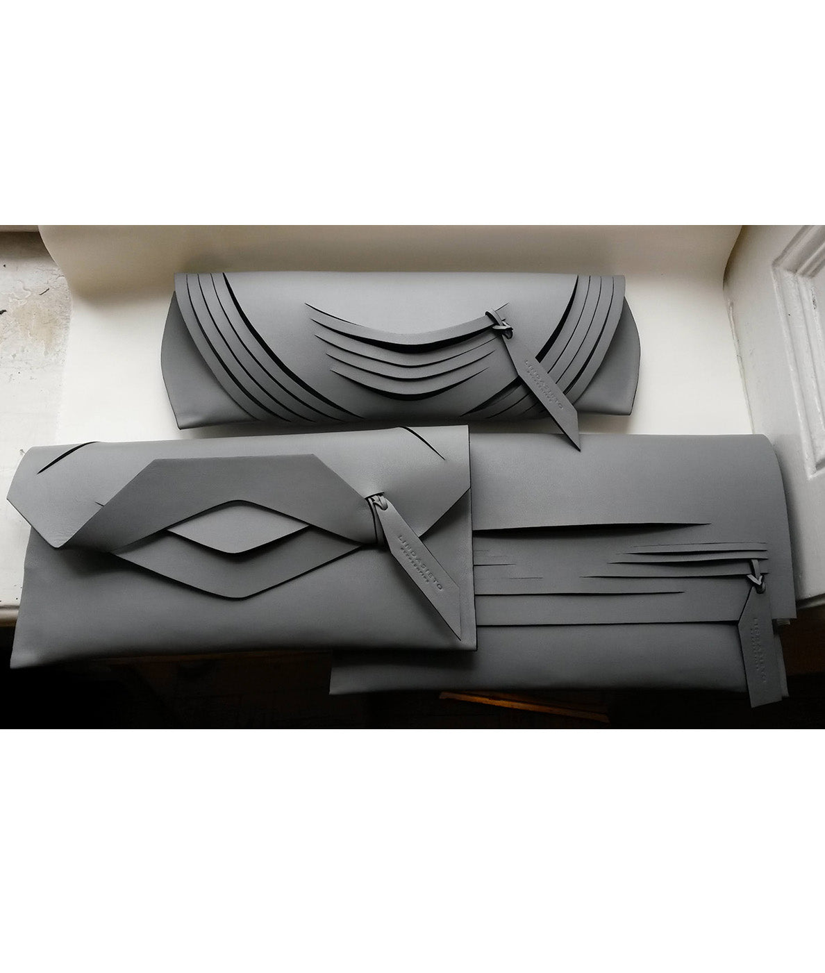 Handmade clutch bag handcrafted from genuine Italian leather, custom colors, black handbag, purse with unique wrist strap by Hungarian, Budapest based designer. Fekete, választható színű bőr designer borítéktáska, táska, magyar táskatervező márka.