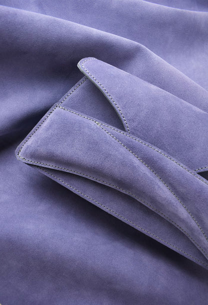 A close-up of a Lindasieto Link Bag, clutch in amethyst lilac purple suede leather with fine stitched edges and soft folds and leather texture. Magyar kortárs designer lila velúr bőr alkalmi női clutch táska, közeli részletfotó a puha olasz hasított bőrről és varrásvonalakról.