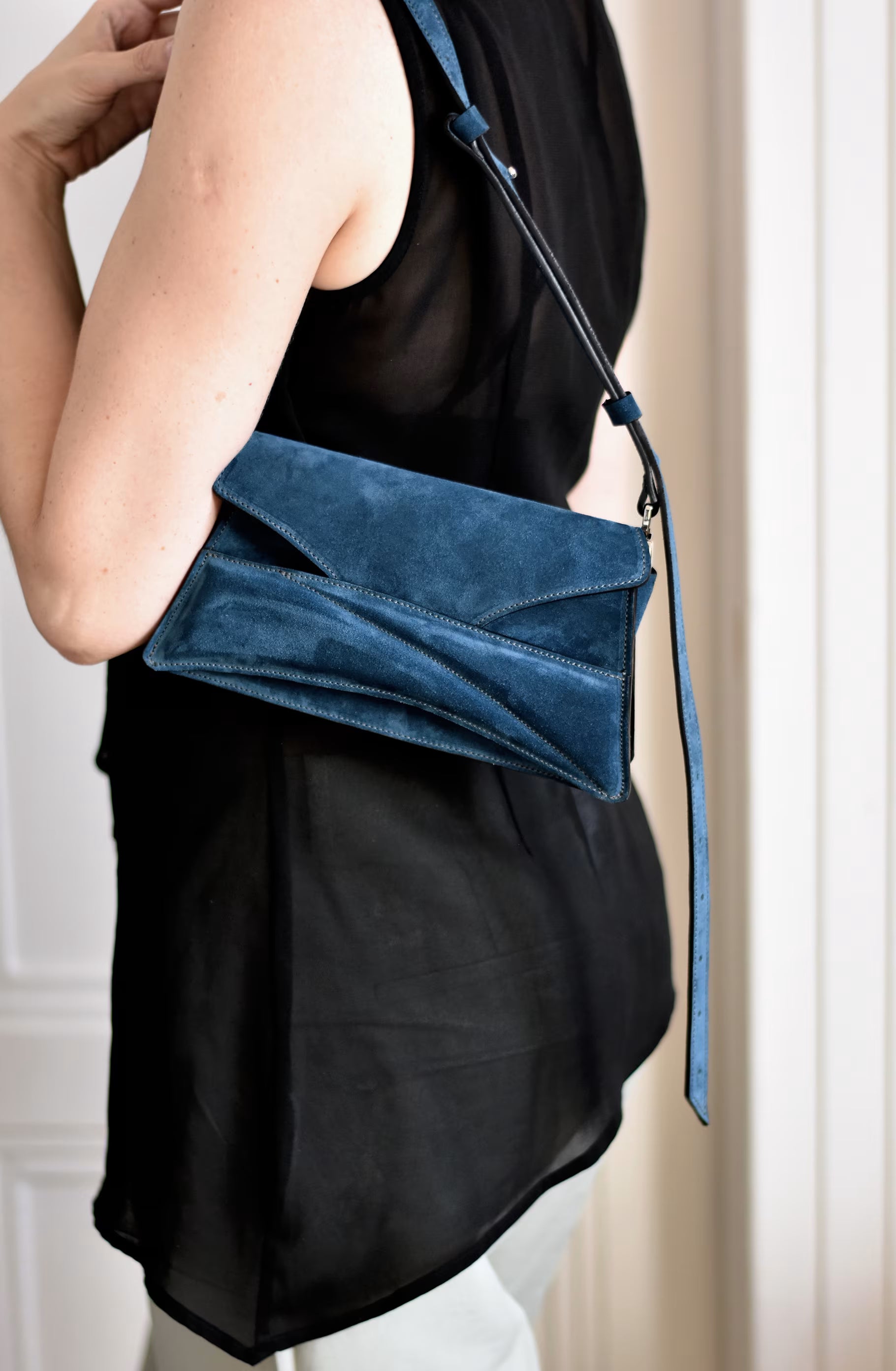 Lindasieto sculptural suede leather Link Bag in midnight azure blue, designer clutch to shoulder bag hybrid style worn on the shoulder with black minimal outfit