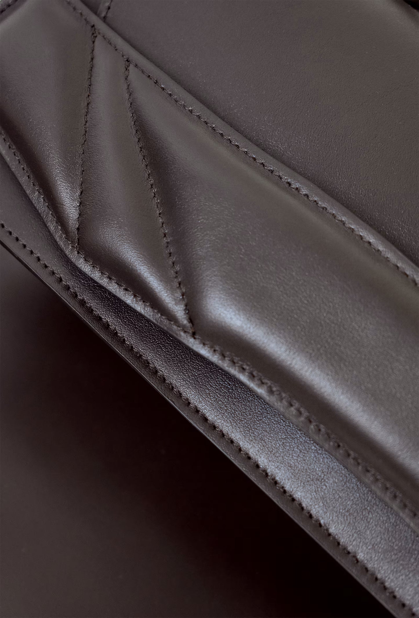 Closeup of sculptural Lindasieto Mini Balance Bag, magyar designer különleges csokolade barna bőr táska, budapest design week. minimalist dark chocolate brown italian nappa leather luxury mini balance bag by Budapest based independent brand.