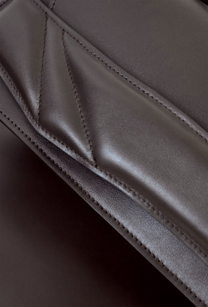 Closeup of sculptural Lindasieto Mini Balance Bag, magyar designer különleges csokolade barna bőr táska, budapest design week. minimalist dark chocolate brown italian nappa leather luxury mini balance bag by Budapest based independent brand.