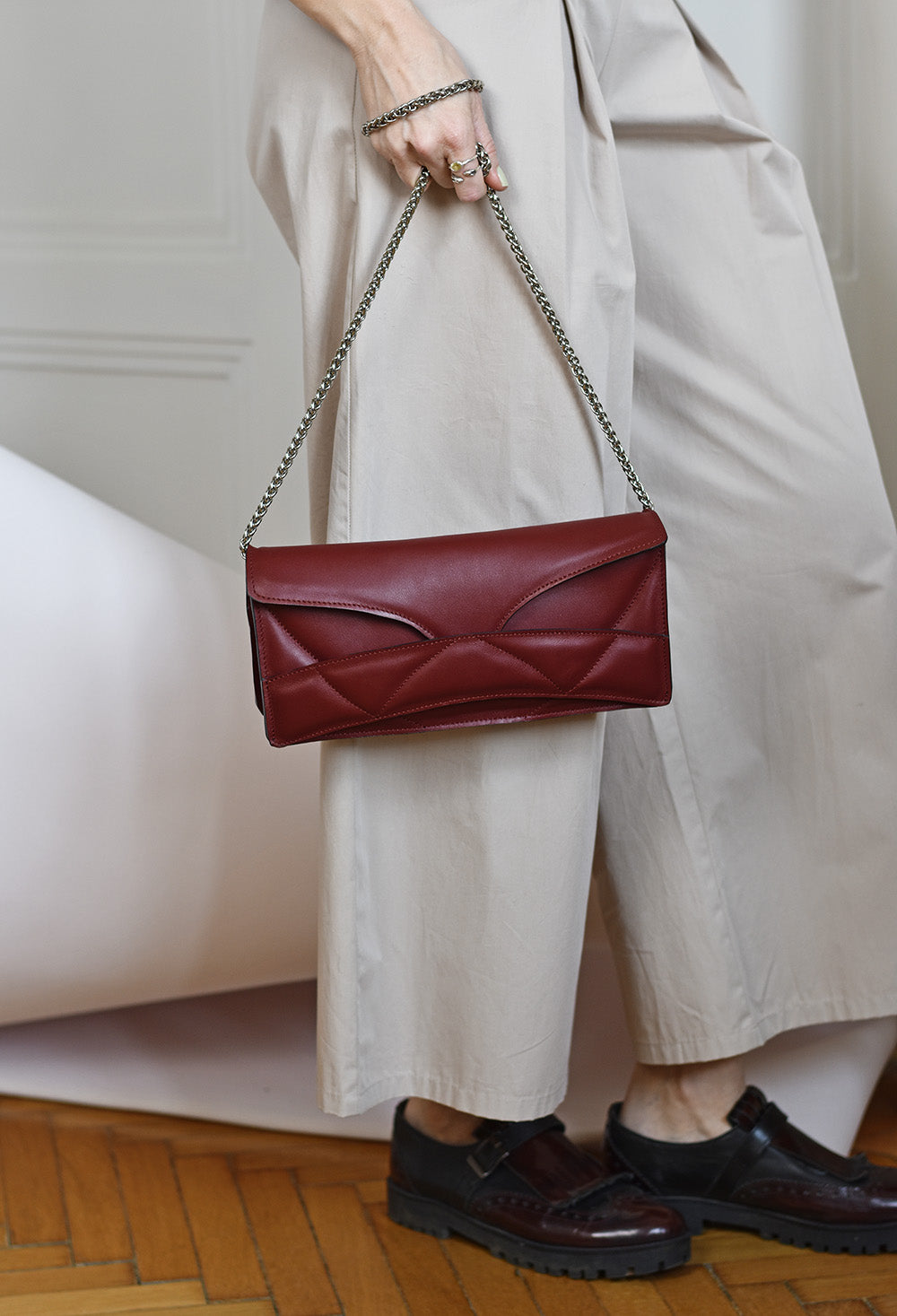 Lindasieto Abstract Heart Bag handcrafted from luxurious Italian dark red nappa leather, sculptural minimalist handbag, crossbody purse with unique wrist strap by Hungarian, Budapest based designer. Piros bordó bőr kortárs designer válltáska magyar táska tervező márka.