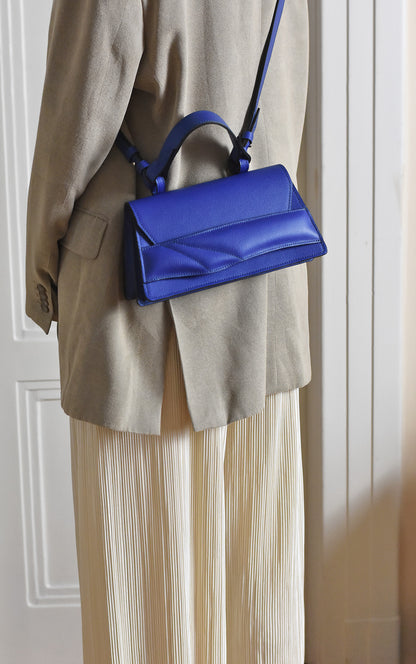 Magyar designer bőr crossbody táska, egyedi, női, uniszex, iparművész válltáska, különleges színekben, személyre szabott monogram, ajándék csomagolással. Handmade genuine leather crossbody bag by Budapest based fashion designer, unique wrist strap handle, gift wrap available. Limited quantities, ethical production.