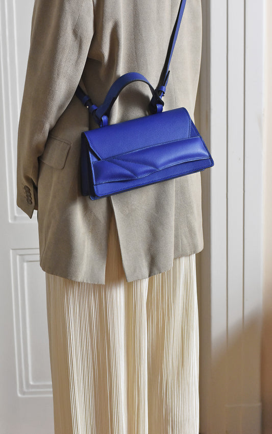 Magyar designer bőr crossbody táska, egyedi, női, uniszex, iparművész válltáska, különleges színekben, személyre szabott monogram, ajándék csomagolással. Handmade genuine leather crossbody bag by Budapest based fashion designer, unique wrist strap handle, gift wrap available. Limited quantities, ethical production.