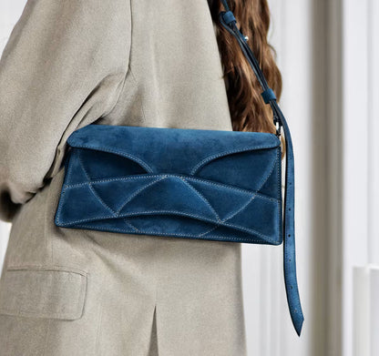 lindasieto magyar designer kék velúr bőr Enigmatic Heart női táska, 2026 tavasz színek. Dark azure blue suede leather clutch to shoulder bag with quilted design, unique wrist strap by Budapest based fashion brand, ss26.