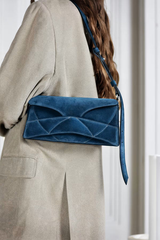 lindasieto magyar designer kék velúr bőr Enigmatic Heart táska, 2026 tavasz színek. Dark azure blue suede leather clutch to shoulder bag with unique wrist strap by Budapest based designer brand, ss26.