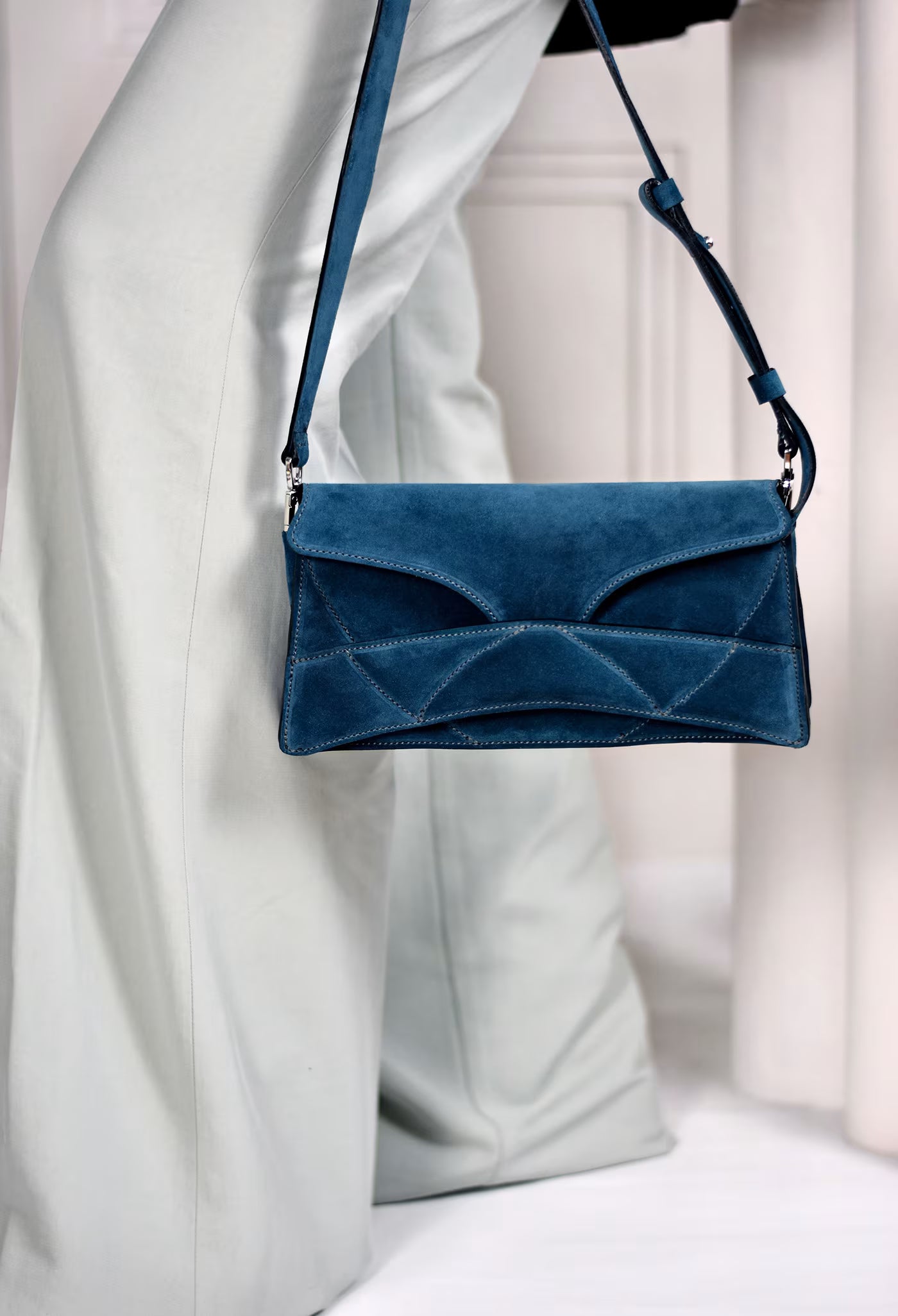 lindasieto magyar designer kék velúr bőr Enigmatic Heart táska, 2026 tavasz színek. Dark azure blue suede leather clutch to shoulder bag with unique wrist strap by Budapest based designer brand, ss26.