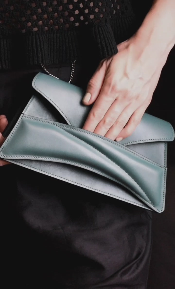 Lindasieto Link Bag, sculptural jade green leather clutch with a chain strap, close up detail of wrist strap and soft, green nappa leather texture. Magyar kortárs designer jade zöld bőr alkalmi női clutch táska, puha bőr csuklóőánt design és varrás részlete