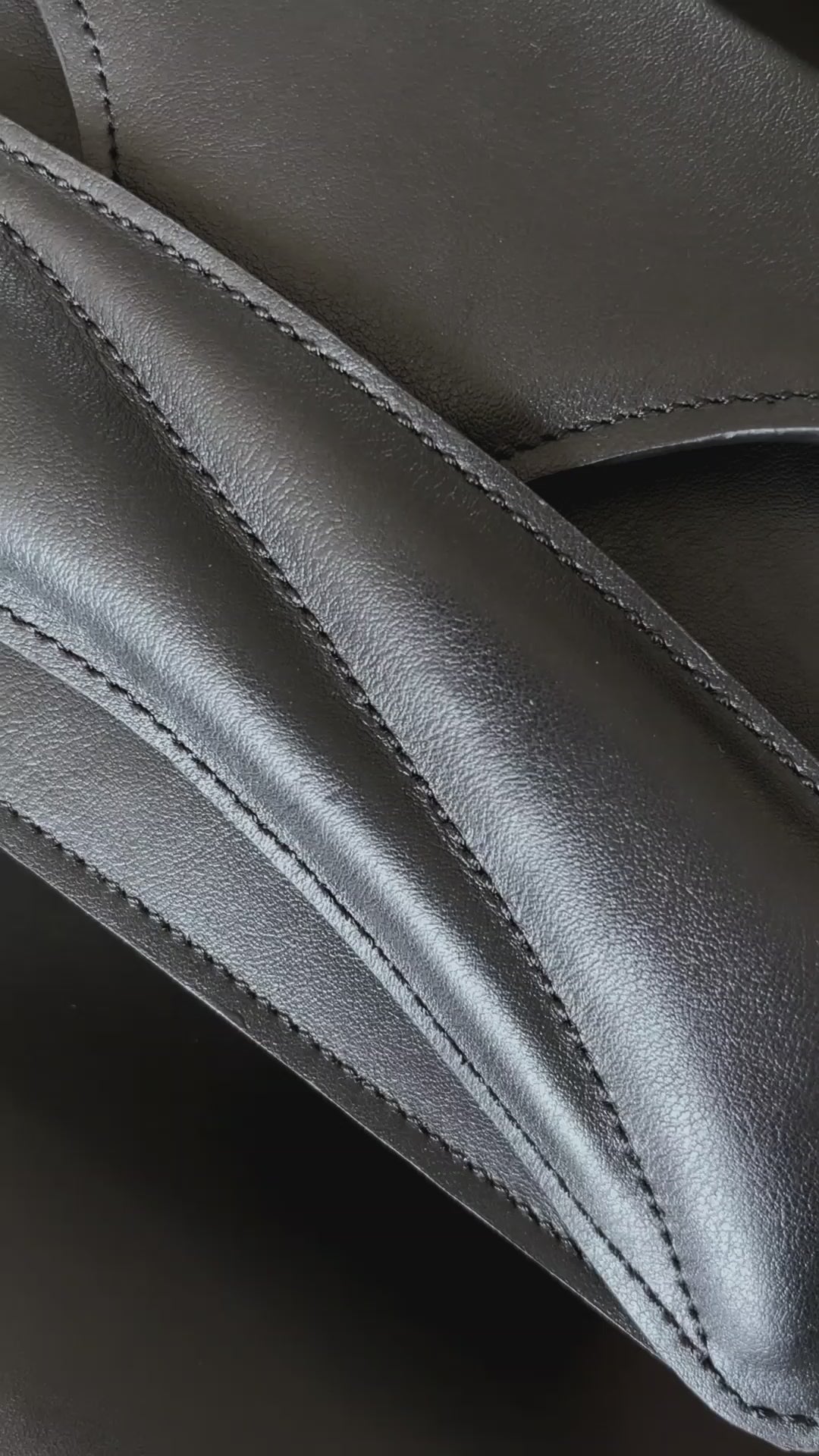 Lindasieto Link Bag, sculptural black leather clutch with a chain strap, close up detail of wrist strap and soft, black nappa leather texture. Magyar kortárs designer fekete bőr alkalmi női clutch táska, puha bőr és varrás részlete